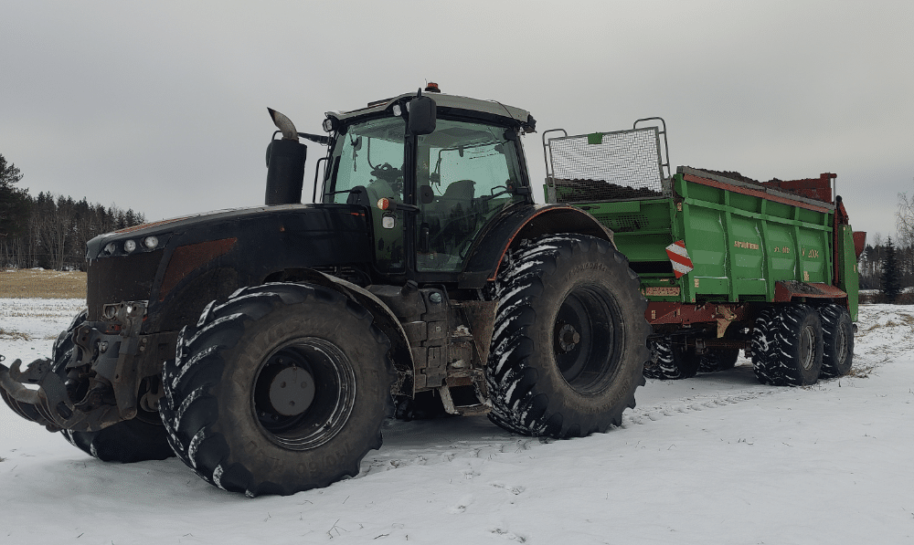 Traktorin perassa kuivalantavaunu kuivalannan levitykseen pelloille.